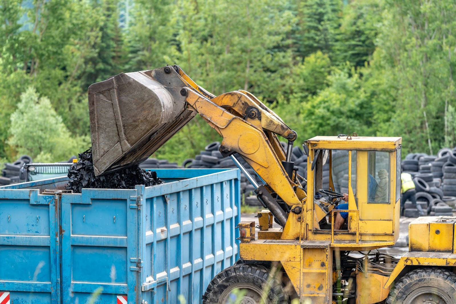 Machinery next to a dumpster. 