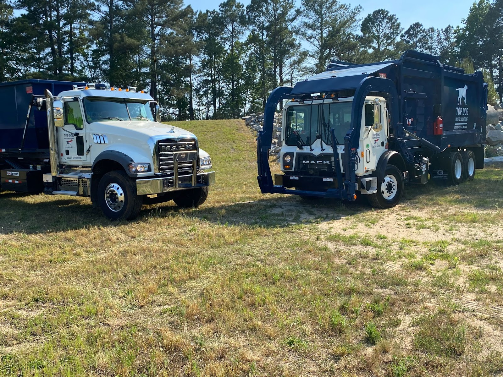 Two junk remover trucks are parked and ready for scheduled trash removal.