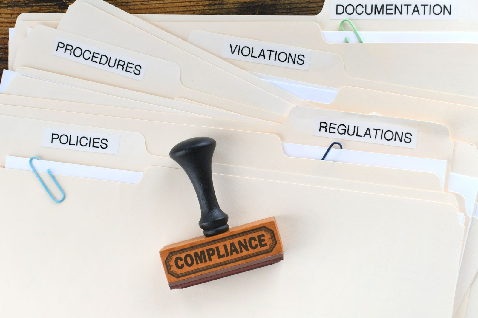 Compliance stamp on stacked files covering trash removal records.