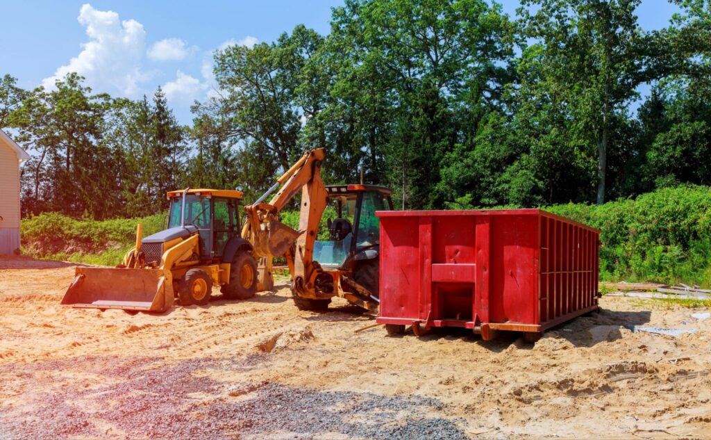 Machinery next to a commercial dumpster.