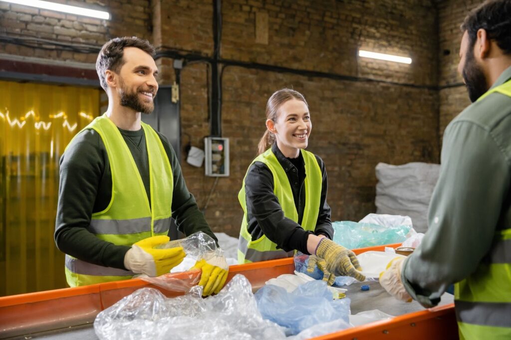 Workers smile as they sort and dispose of universal waste.