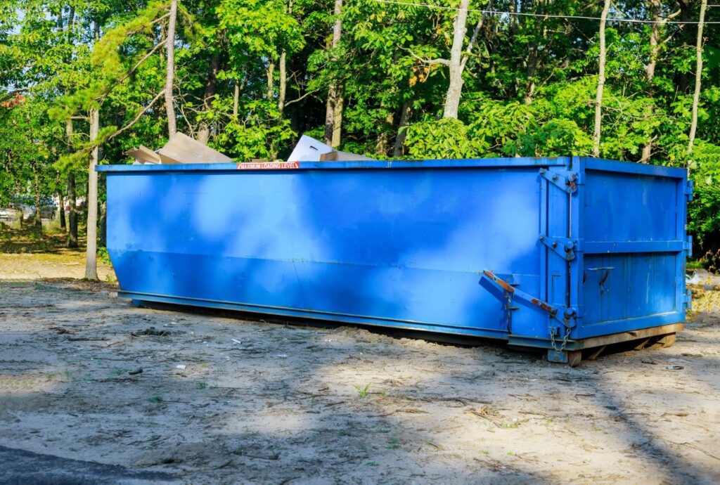 A large blue dumpster sitting at its rental site.